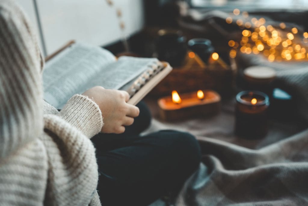 A-girl-with-a-Bible-sitting-by-candles.jpg