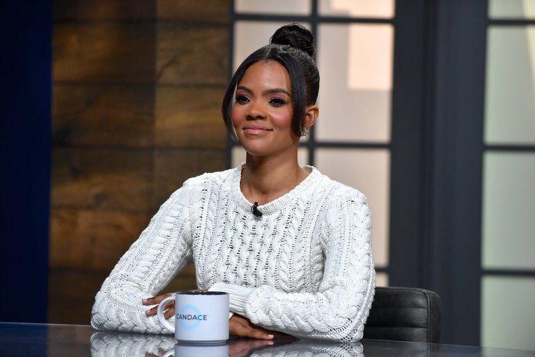 Candace Owens at a desk with a CANDACE mug