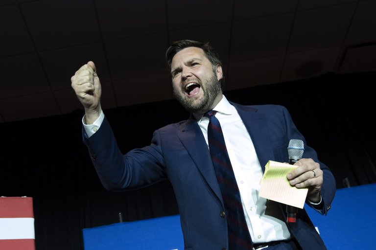J.D. Vance raising his fist in celebration on stage